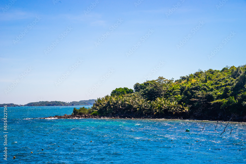 Naklejka premium Hon Thom island in Phu Quoc, Vietnam, Asia - Tropical view with colorful houses, blue waves and blue sky, fishing boats and far away is a longest cable car