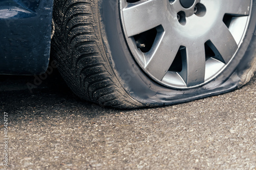 flat car tire close up, punctured wheel