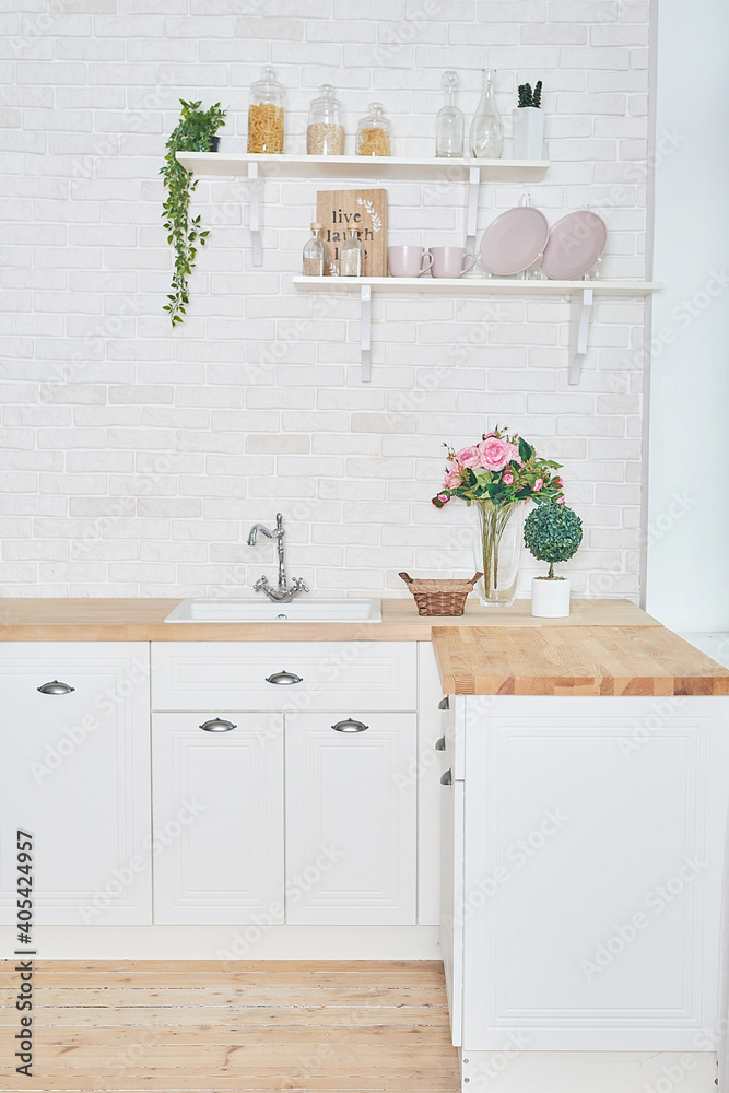 White kitchen in interior loft style. Valentine's day kitchen decor. Kitchen utensils and shelves. White kitchen in interior loft style. Valentine's day kitchen decor. Kitchen utensils and shelves.