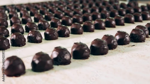 Chocolate candies are moving along the industrial mechanism photo