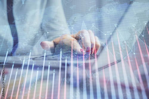 Double exposure of businesswoman hands typing on computer and financial graph hologram drawing. Stock market analysis concept.