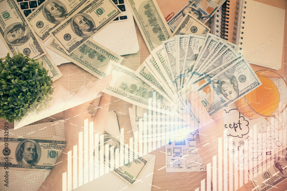 Multi exposure of financial graph drawing hologram and USA dollars bills and man hands. Analysis concept. Multi exposure of financial graph drawing hologram and USA dollars bills and man hands. Analysis concept.