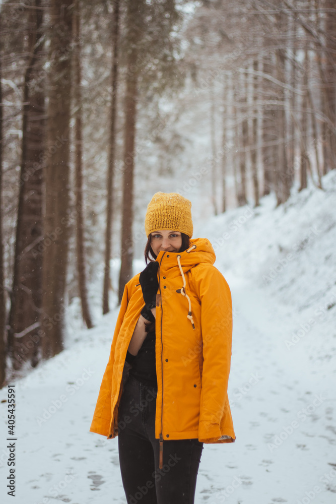 Gorgeous brown-haired girl aged 20-24. The girl is in a yellow to fortuna gold tones jacket covering her face. Young sportswoman on a snowy road. Portrait of a girl with blue eyes in a snowy landscape Gorgeous brown-haired girl aged 20-24. The girl is in a yellow to fortuna gold tones jacket covering her face. Young sportswoman on a snowy road. Portrait of a girl with blue eyes in a snowy landscape