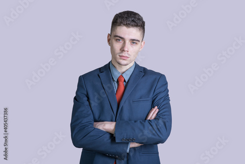 Portrait of a young boy in a suit with his arms crossed