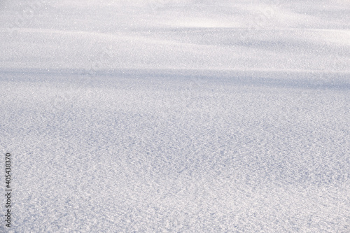Snow texture. Background of fresh snow texture in blue tone. White texture with copy space. Fresh snow in the alps. Copy space of a sleek white background.