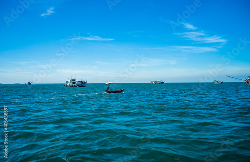 Fototapeta Naklejka Na Ścianę i Meble -  Hon Thom island in Phu Quoc, Vietnam, Asia - Tropical view with colorful houses, blue waves and blue sky, fishing boats and far away is a longest cable car