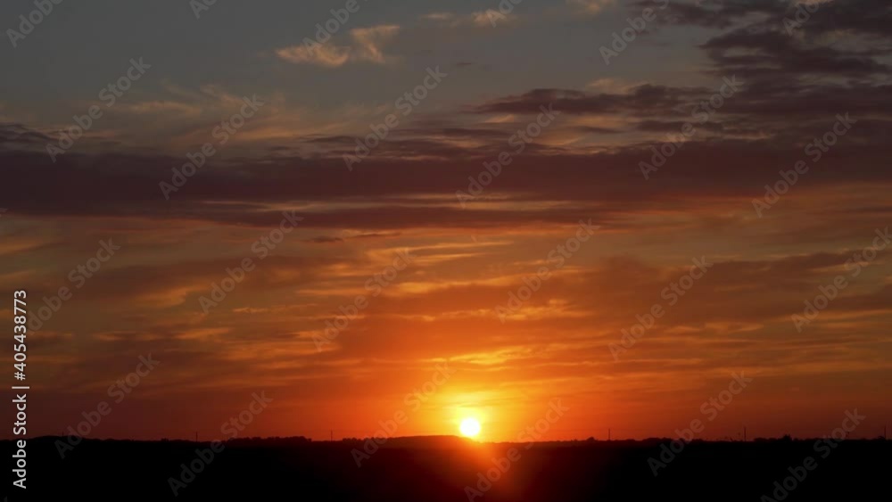Beautiful Dramatic Time Lapse of Sunset and Colorful Clouds. The Sun Sets over the Horizon in a Field, Sliding the Camera. The Multi-Colored Sky at Sunset. Beautiful Dramatic Time Lapse of Sunset and Colorful Clouds. The Sun Sets over the Horizon in a Field, Sliding the Camera. The Multi-Colored Sky at Sunset.