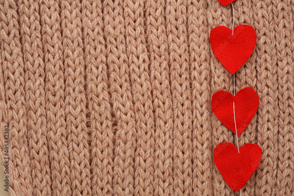 Hearts cut from fabric on a thread, on a knitted background. Valentine day card
