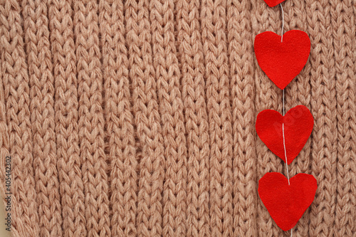 Hearts cut from fabric on a thread  on a knitted background. Valentine day card