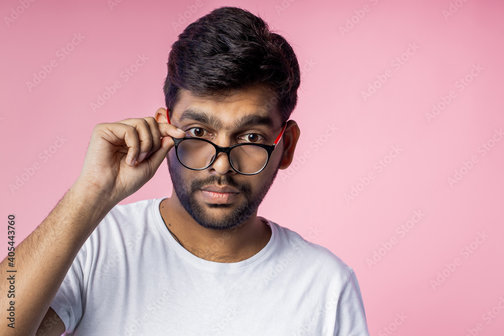 Portrait of handsome Indian guy standing on pink background Portrait of handsome Indian guy standing on pink background