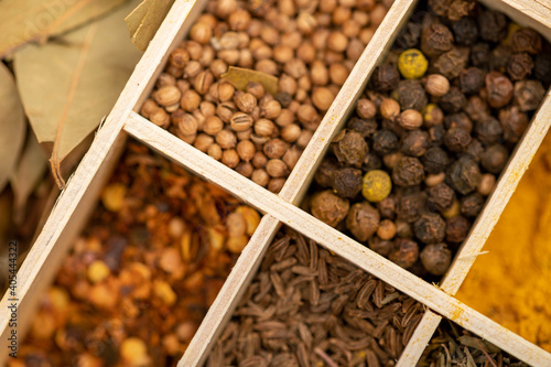 A set of different spices in a wooden box. Close-up, selective focus.