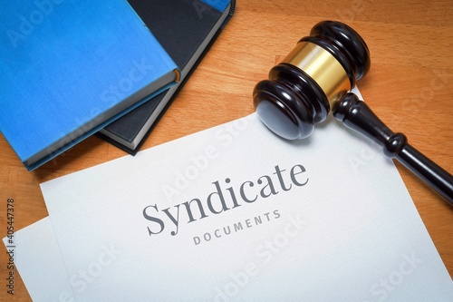 Syndicate. Document with label. Desk with books and judges gavel in a lawyer's office.