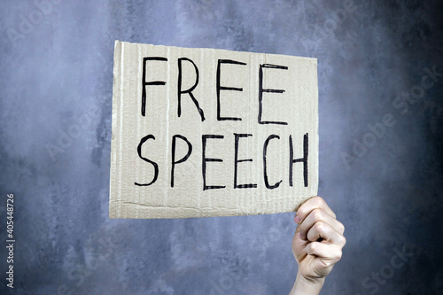 hand holds a banner with the inscription free speech, censorship concept photo