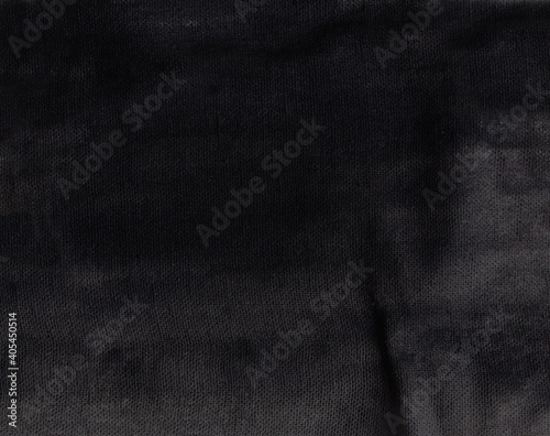 Black dyed cotton rag with folds and wrinkles as a background for design and decor