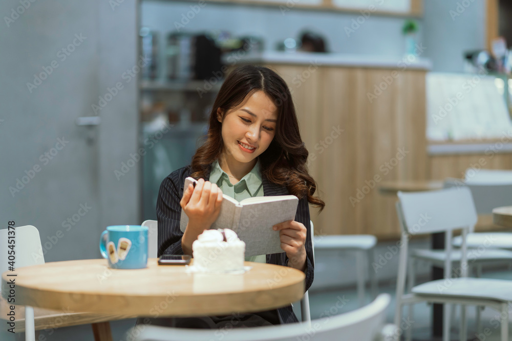 Happy young businesswoman reading a book at the cafe Happy young businesswoman reading a book at the cafe