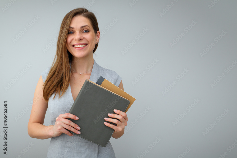 Smiling teacher holding books and standing near to copy space. Isolated female portrait. Smiling teacher holding books and standing near to copy space. Isolated female portrait.