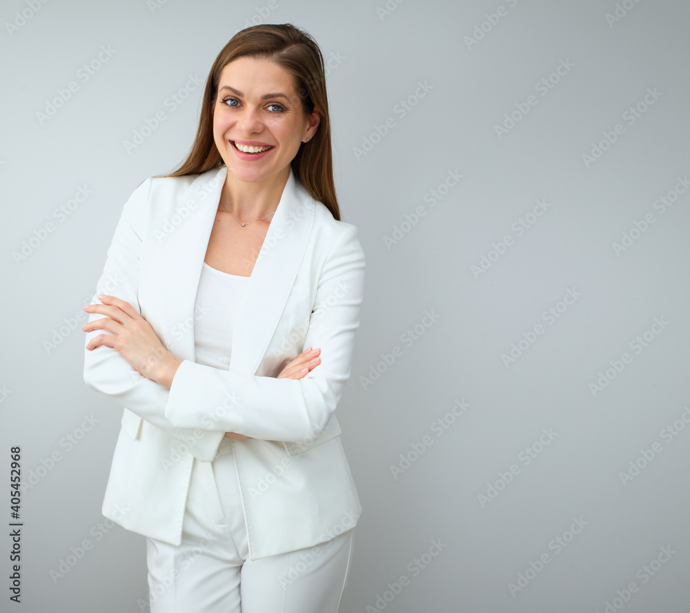 Business woman in white business suit standing with crossed arms.
