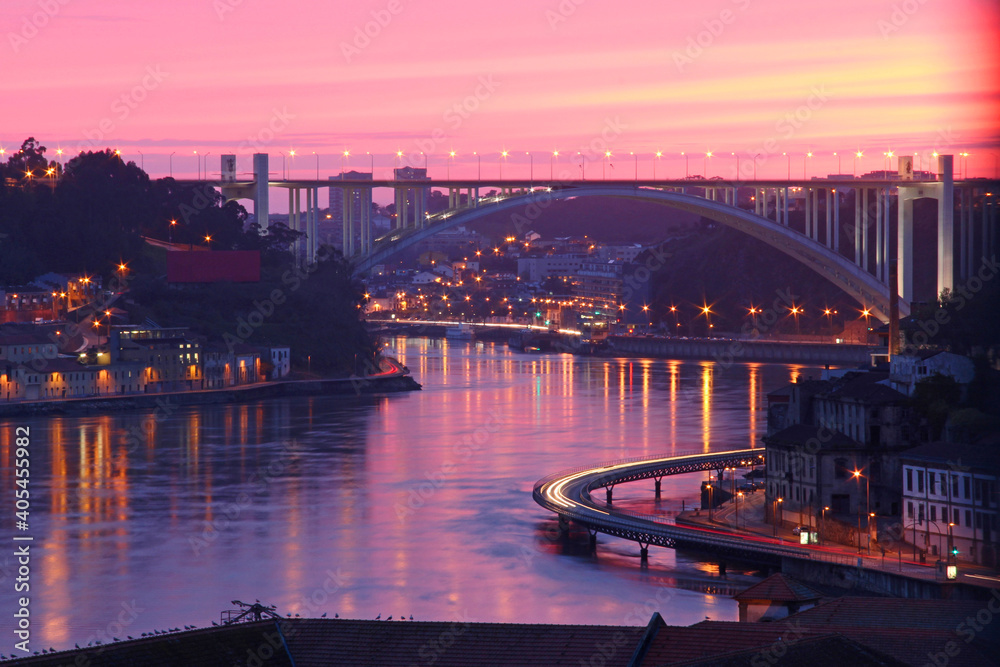 Skyline of the City of Porto in Portugal at the river douro during sunset with brigde, traffic and car lights