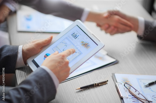 businessman using a digital tablet to analyze financial data.