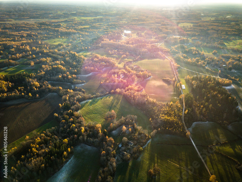 Aerial Drone Photo of Green Meadows Partly Snow Covered, Surrounded by Forests