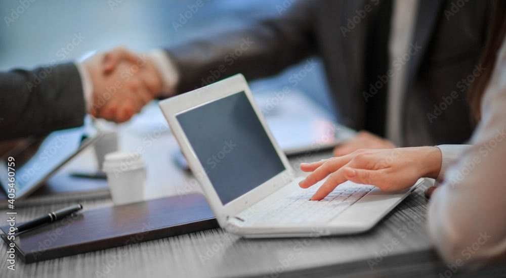business colleagues shaking hands over a work Desk. close up. business colleagues shaking hands over a work Desk. close up.