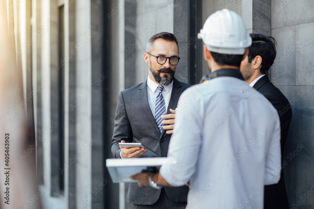 Hipster business man and Office building owner and energy engineer plan a project to build a solar panel for the building under construction. clean and green alternative energy concept.