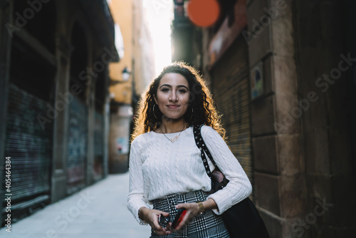 Smiling young woman with smartphone on street © GalakticDreamer