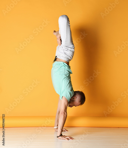 Canvastavla Mature active bearded grey-haired man standing in inverted yoga pose on straight arm with leg folded in lotus position