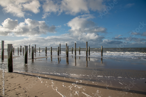 Wooden poles at the beach near Petten aan Zee, Holland. © Bert