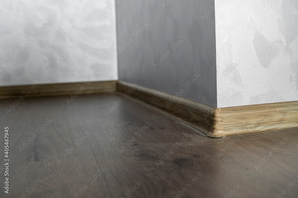 Laminate with plastic baseboard with a wooden texture. Newly installed ...