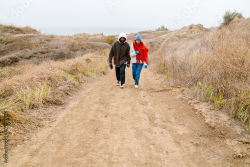 Attractive young multiethnic couple walking at the beachside