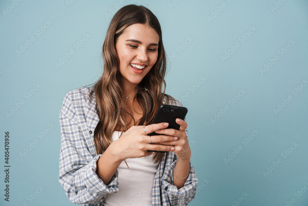 Beautiful young girl in casual wear using mobile phone Beautiful young girl in casual wear using mobile phone