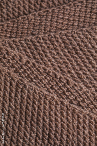 Texture of knitted fabric from brown yarn. Traditional hobby.