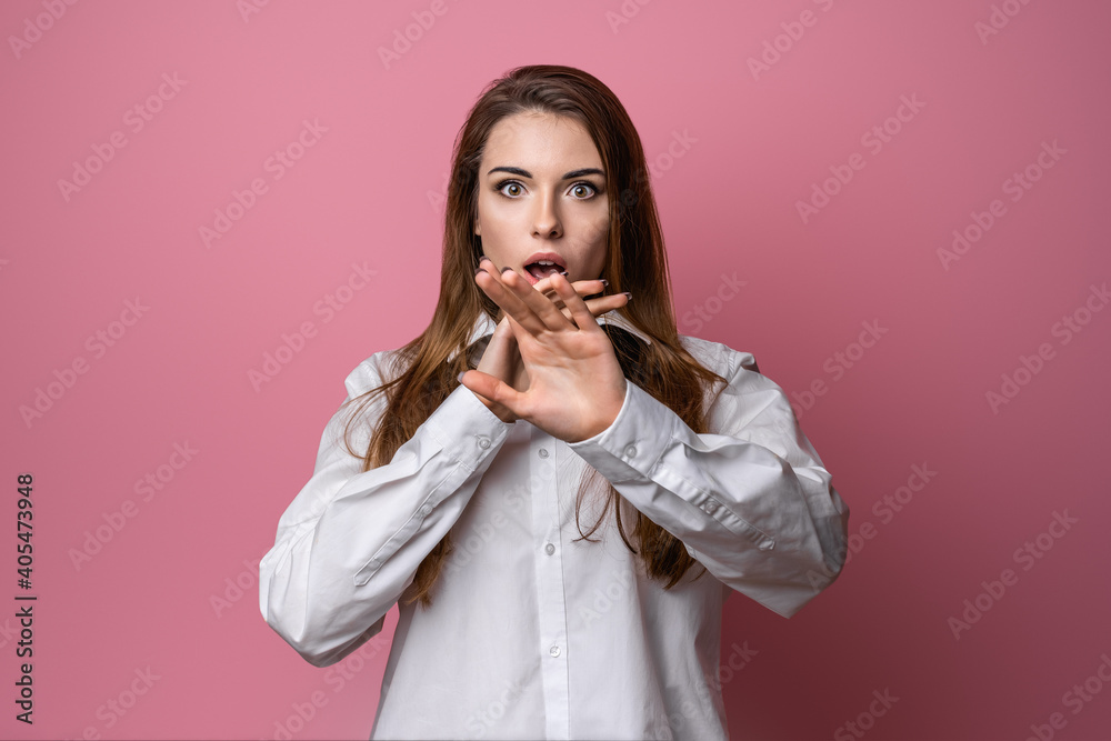 Portrait of startled young brunette woman raising hands and gasping worried, staring shocked and confused at camera Portrait of startled young brunette woman raising hands and gasping worried, staring shocked and confused at camera