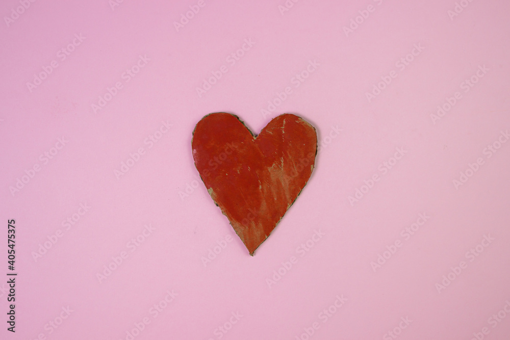 Cardboard heart on a pink background. An inaccurately painted heart. Red heart. Health concept