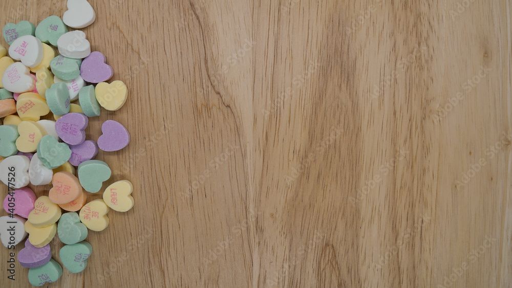 Candy conversation hearts form a border on a wooden background for Valentine's Day, leaving room for copy. Candy conversation hearts form a border on a wooden background for Valentine's Day, leaving room for copy.