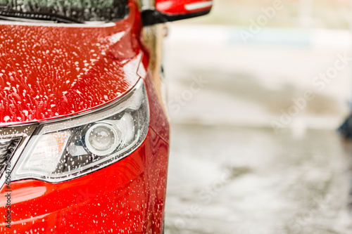 headlight of a red car at a car wash
