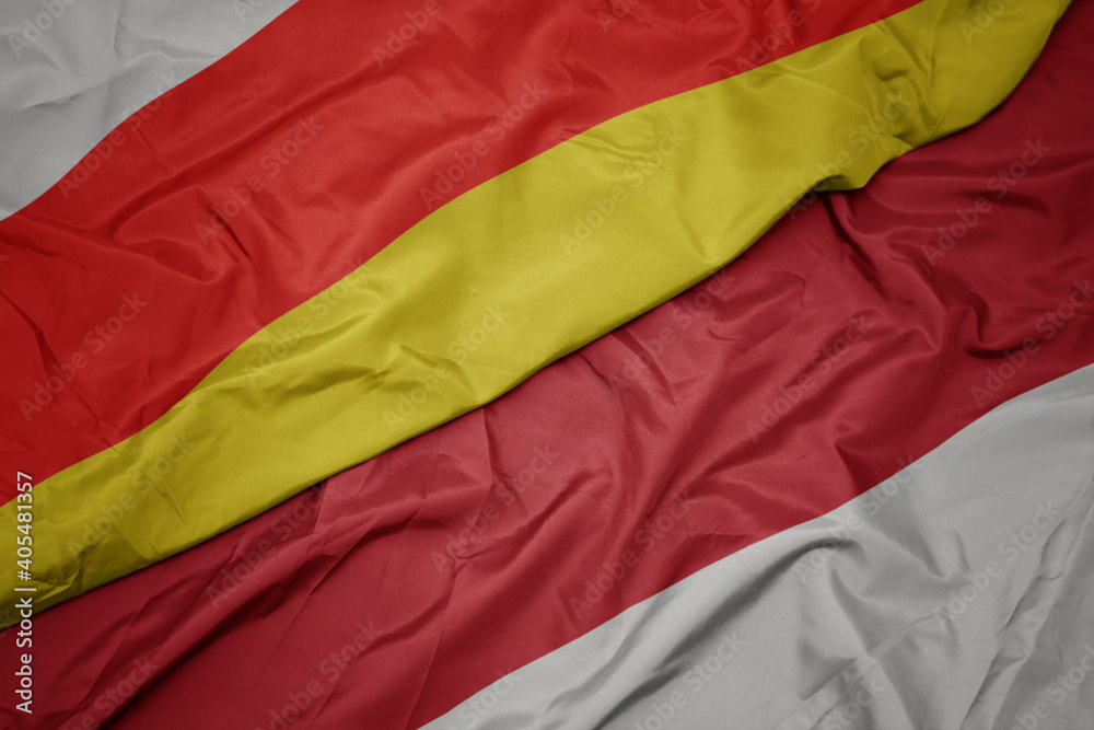 waving colorful flag of indonesia and national flag of south ossetia. waving colorful flag of indonesia and national flag of south ossetia.
