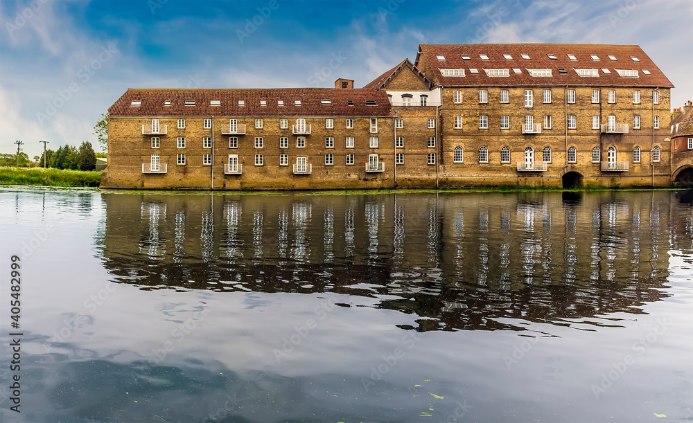 The mill at Riverside, Godmanchester reflected in the calm waters of the River Great Ouse in springtime