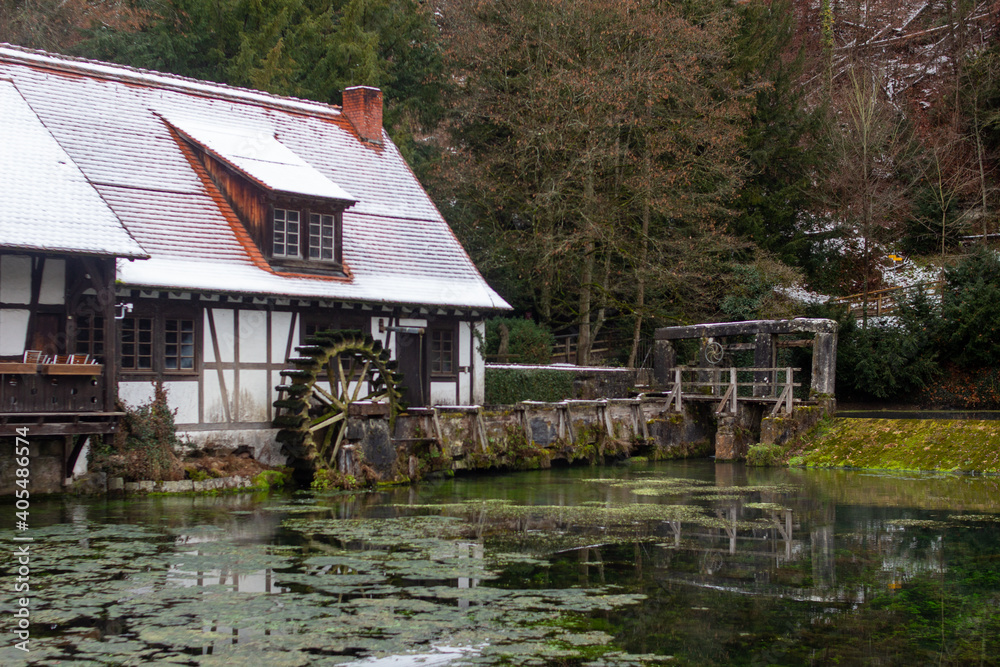 Obraz premium Altes Fachwerkhaus mit einem Wasserrad an einem See