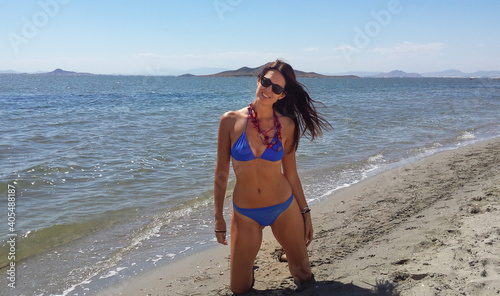 Young slim beautiful woman stay and posing in the sea or ocean waves