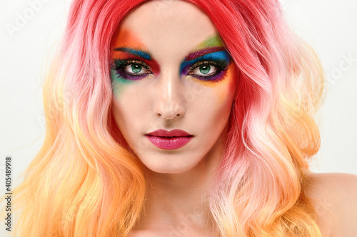 Beauty Fashion woman with Colorful Bright Art Makeup, Pink Dyed Hairstyle. Girl with blue eyes, stylish hair, make up. Beautiful model portrait, fashionable color trend creative make-up.