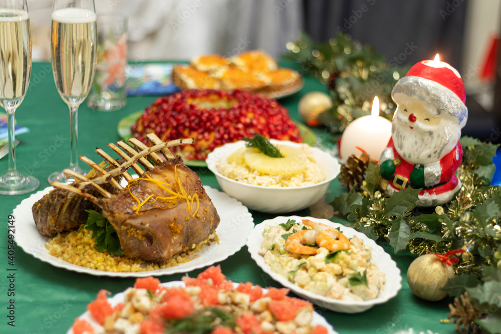 A festive table with many delicious dishes. Lamb rack, two glasses of champagne, salads and snacks on the festive table. A festive table with many delicious dishes. Lamb rack, two glasses of champagne, salads and snacks on the festive table.