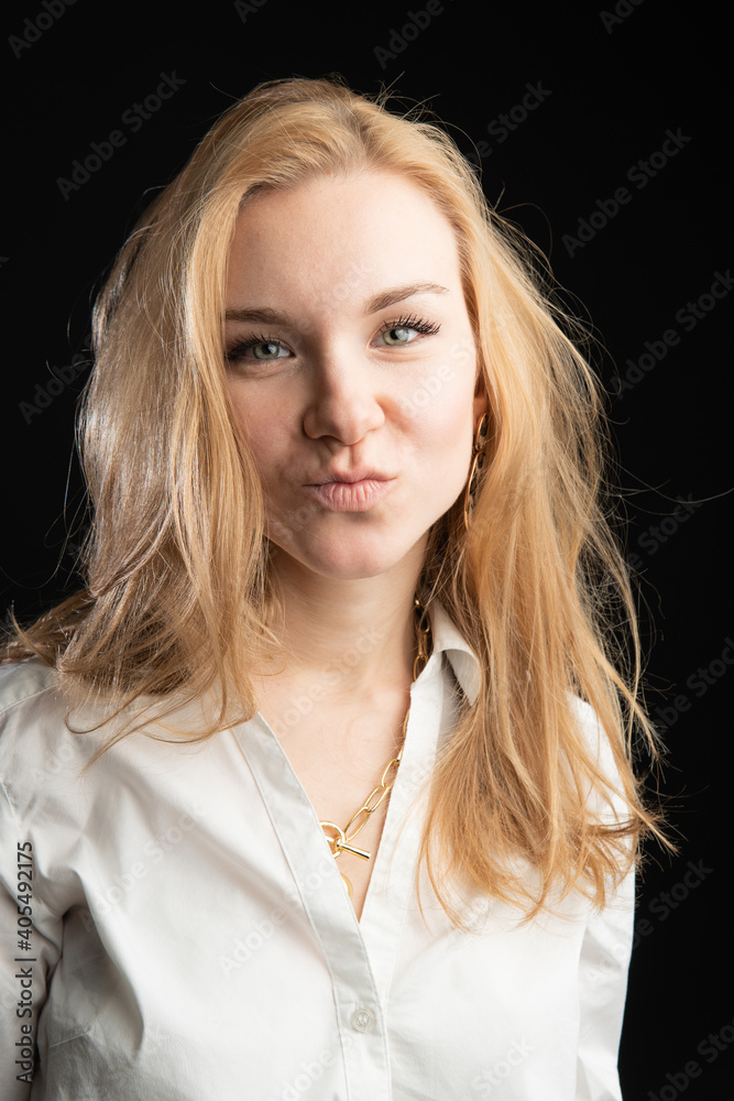 stands on a black background in a white blouse. Beautiful, well-being concept, in the studio, business woman, blonde stands on a black background in a white blouse. Beautiful, well-being concept, in the studio, business woman, blonde