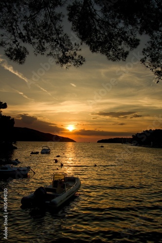 Sunset under calm Mediterranean Sea with silhouette of ship in town Stary Grad, island Hvar, Croatia, Europe photo