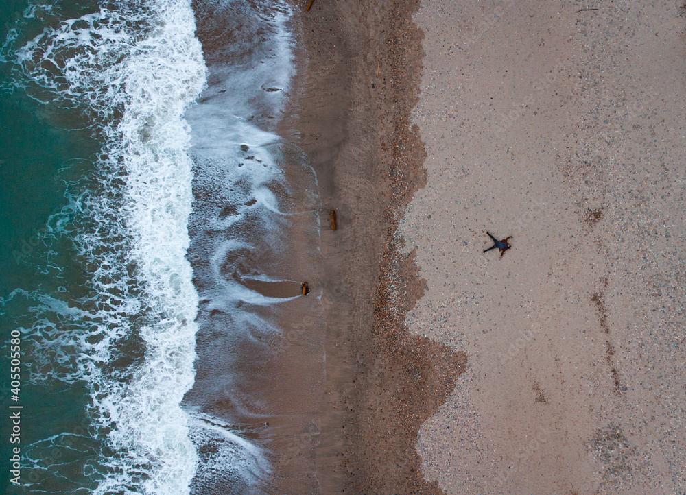 Prise de vue aérienne, d'un homme en étoile sur une plage, environ 110m de hauteur