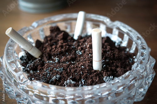 Ashtray with extinguished cigarettes full of ashes. No people.