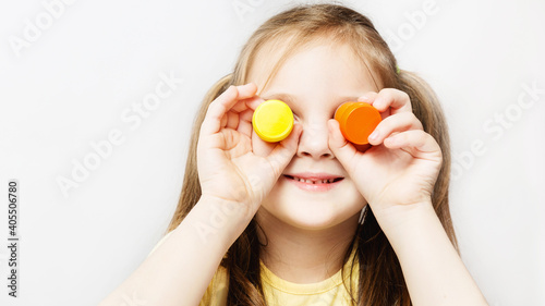 caucasian preschool little girl holding gouache cans in her hands on white background