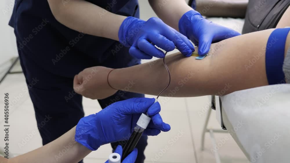 Doctors in medical uniforms take blood from women for analysis of coronavirus research in a modern clinic. Doctors in medical uniforms take blood from women for analysis of coronavirus research in a modern clinic.