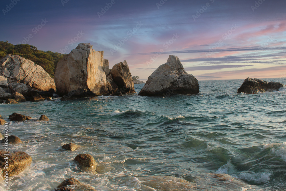 Rocks , stones and sunset on the beach and exotic blue and pink sky Rocks , stones and sunset on the beach and exotic blue and pink sky
